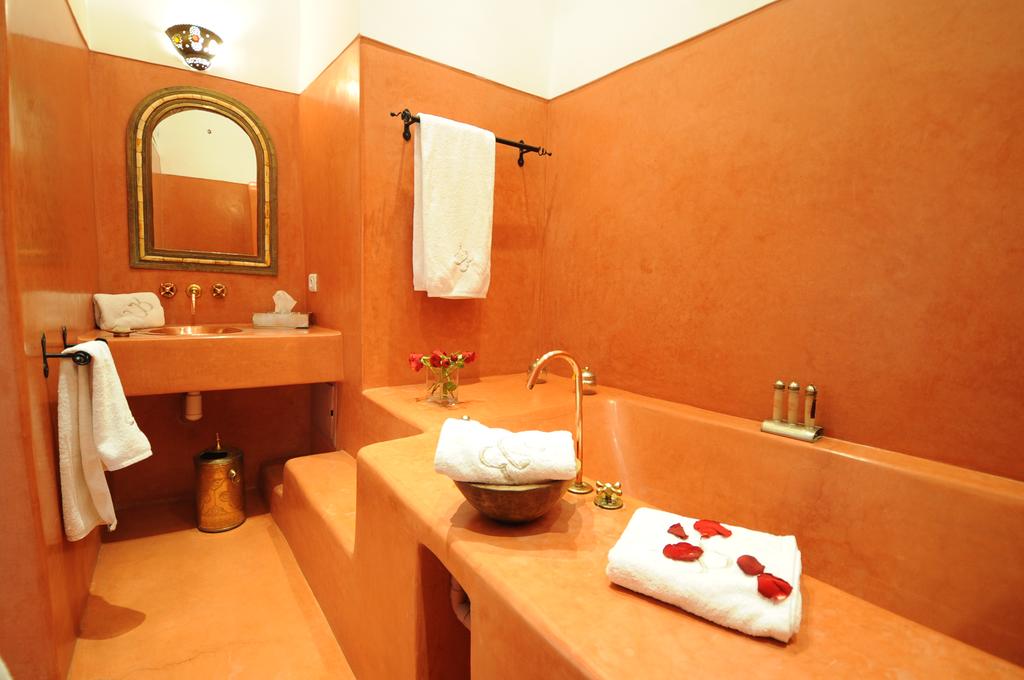 Bagno con vasca, lavandino e pavimento in tadelakt rosso
